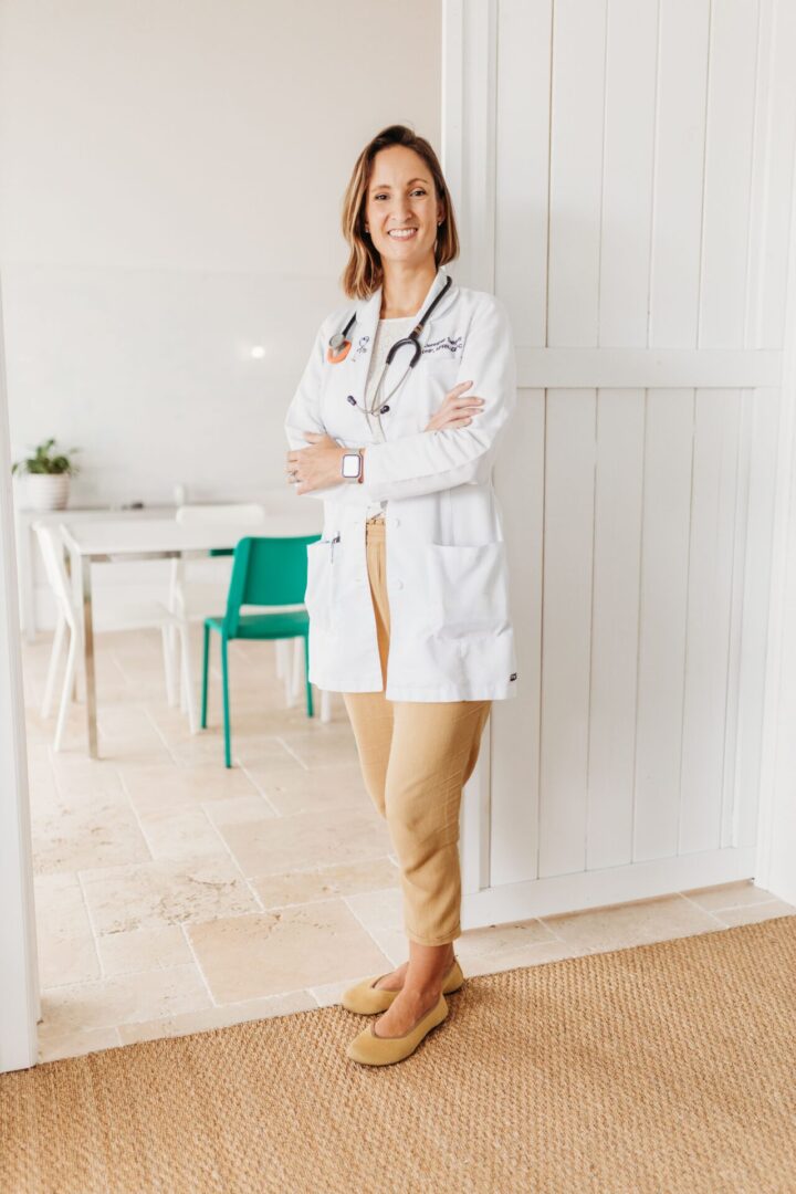 A woman standing in front of a table with her arms crossed.