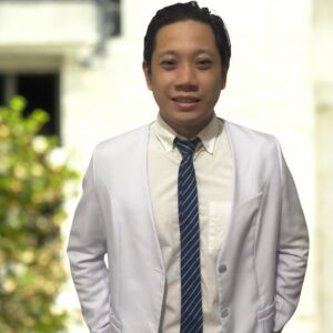 Smiling man in white blazer with striped tie